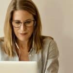 HappyMaps. Woman working on laptop with headphones, remote work, digital map, online navigation.